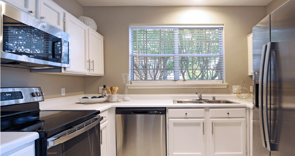 Luxury apartments with kitchen with white cabinets and stainless-steel appliances at The Saxony Apartments