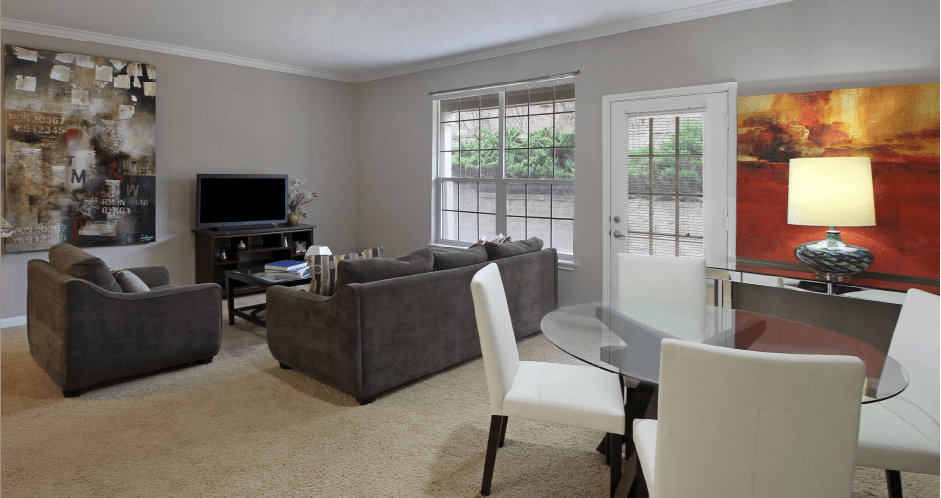 Apartments in southwest Omaha with spacious layout, open floor plan, oversized windows, and gray wall color at Breckenridge Apartments