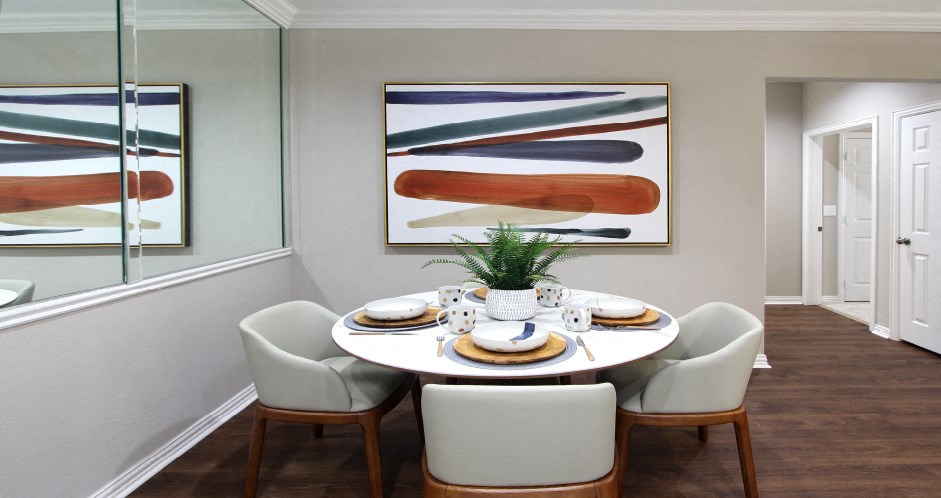 Spacious dining room with mirror accent wall and plank wood floors at TurtleCreek apartments in West Des Moines, Iowa