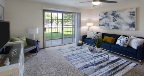 a living room with a blue couch and a sliding glass door