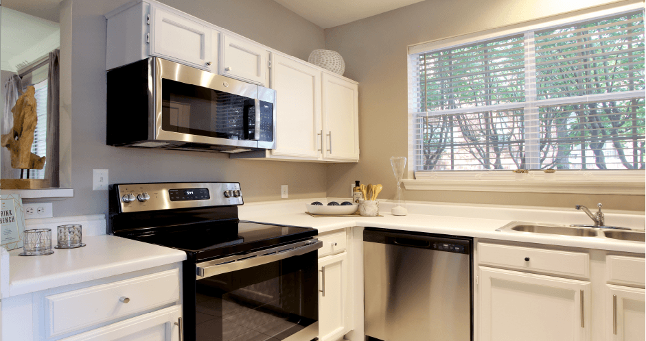 Luxury apartments with kitchen with white cabinets and stainless-steel appliances at The Saxony Apartments
