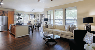 Luxury apartments in Houston with spacious open floor plan with granite countertops, kitchen island, stainless steel appliances, oversized windows, lots of natural light, and hardwood floors.