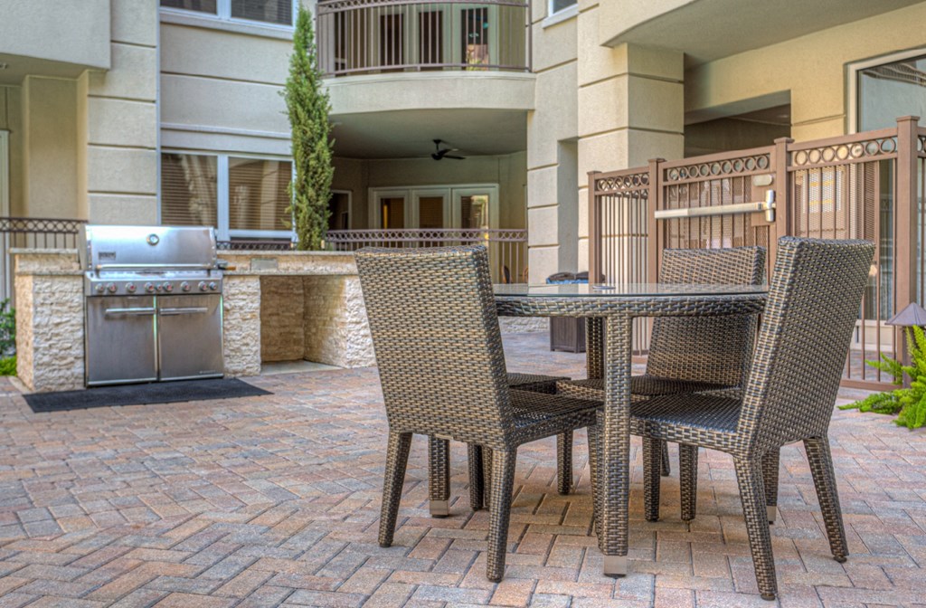 Resident grilling station and sitting area in the courtyard at Tuscany Walk Apartments in Houston Texas