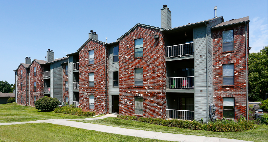 Green and red brick exterior, beautiful landscaping, scenic views, lots of trees, and spacious balconies at LionsHead Apartments in Omaha, Nebraska