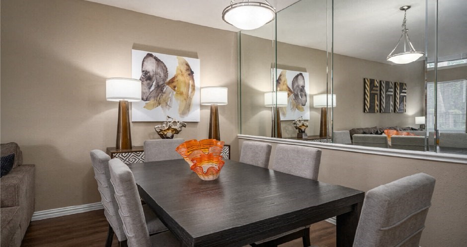 Dining area with mirror accent wall at Woodlake on the Bayou Apartments in Houston Texas