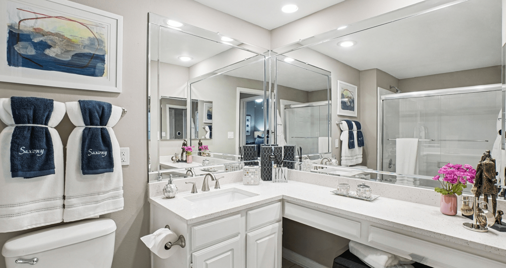 A bathroom with a white toilet, two sinks, and a large mirror.