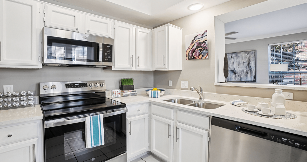 A kitchen with white cabinets and a black stove top oven.