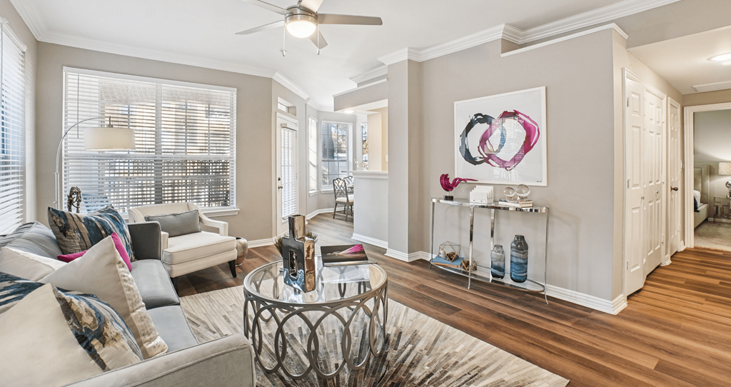 A living room with a sofa, a coffee table, and a painting on the wall.