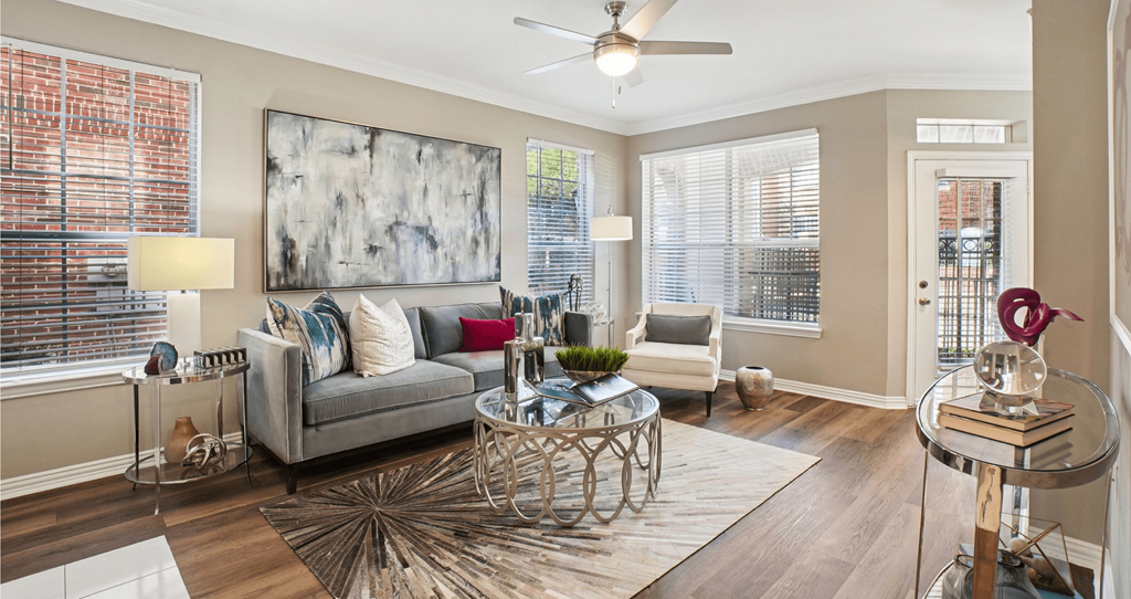 A living room with a grey couch, a coffee table, and a painting on the wall.
