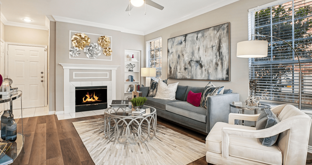 A modern living room with a fireplace and a large painting on the wall.