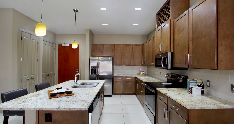 Luxury apartments with spacious open floor plan, granite countertops, stainless steel appliances, built-in wine rack, kitchen island, and porcelain tile floor at Bellemeade Apartments in west Des Moines