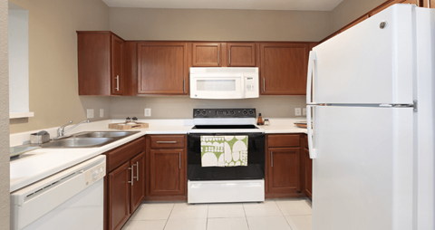 a kitchen with white appliances and wooden cabinets