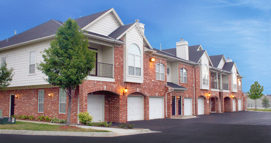 Luxury apartments in central Omaha with attached garages, red brick exterior, lush landscaping, and scenic views at The Biltmore Apartments