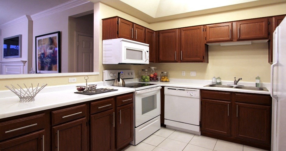 Spacious kitchen with lots of cabinet space, side-by-side refrigerator, porcelain tile floors, and lots of counter space at The Biltmore Apartments in Omaha, Nebraska
