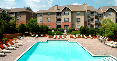 Resort-style pool with large sundeck, poolside lounge chairs, lush landscaping, beautiful landscaping, park-like setting with lots of trees at Breckenridge Apartments in southwest Omaha, Nebraska
