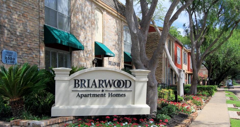 a brick apartment building with a sign in front of it