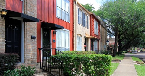 A row of houses with red and beige siding.