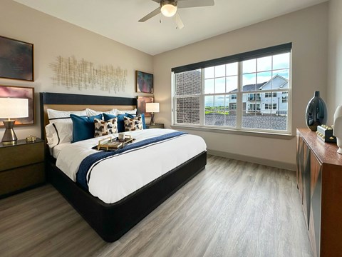 A bedroom with a large bed and a ceiling fan.