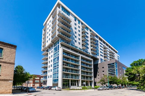 an apartment building on a city street with a blue sky