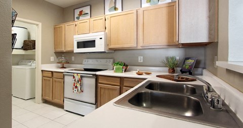 a kitchen with white appliances and wooden cabinets