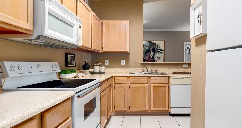 Luxury apartments with spacious kitchen, wood plank floors, breakfast bar, washed oak cabinets, granite countertops, extra pantry storage, and 9-foot ceilings at Kensington Square Apartments.