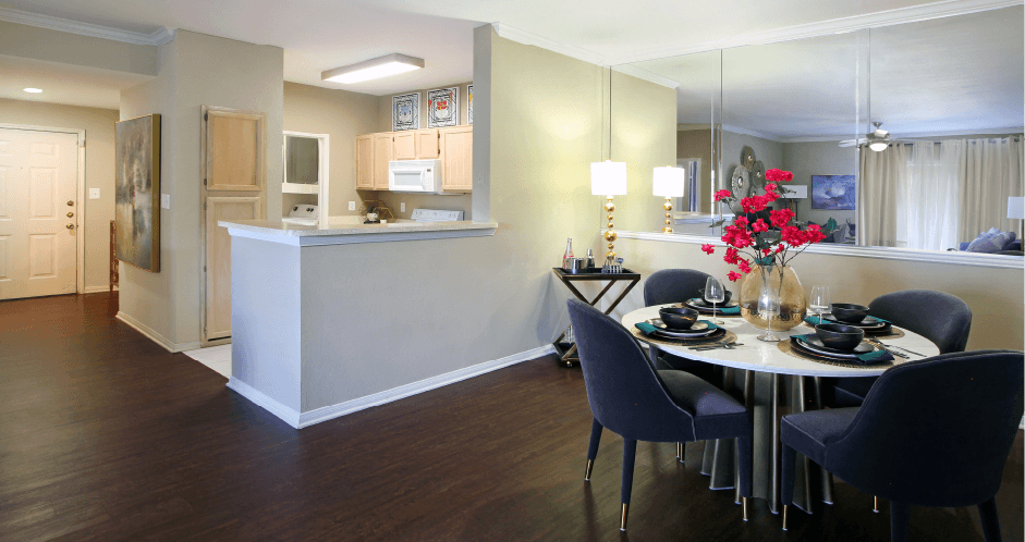 Luxury apartments with spacious kitchen, wood plank floors, breakfast bar, washed oak cabinets, mirror accent wall, spacious dining room, extra pantry storage, and 9-foot ceilings at Kensington Square Apartments.