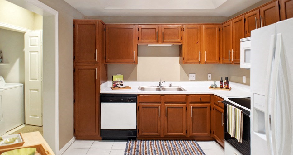 a kitchen with wooden cabinets and white appliances