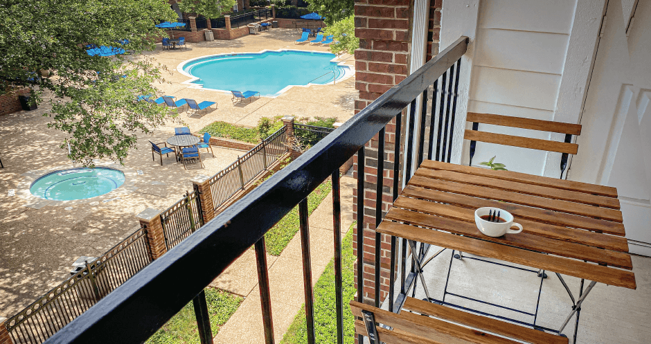 Gated community near the Galleria with brick exteriors, lush landscaping, two swimming pools with poolside lounge chairs, spa, and sauna at The Dorchester Apartments in north Dallas.