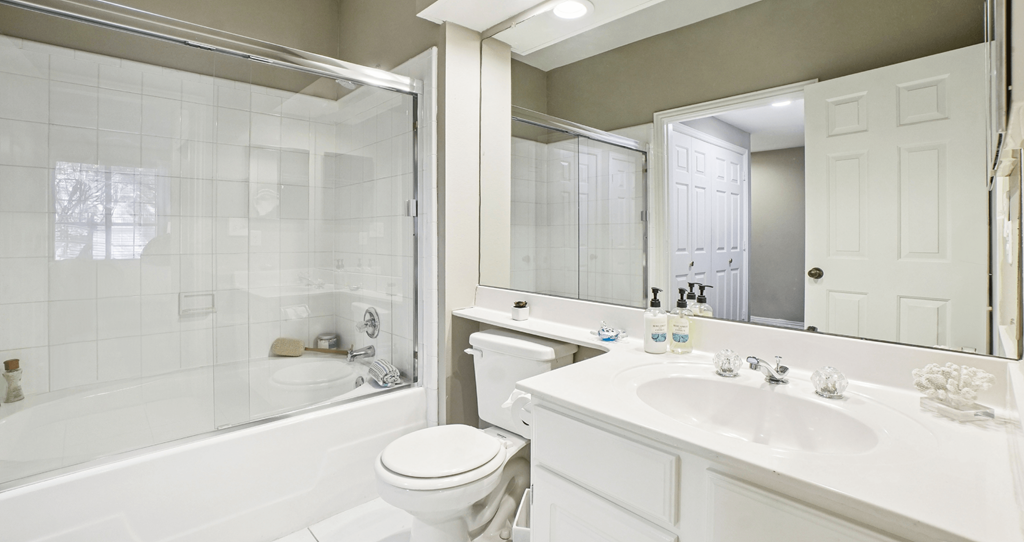 A white bathroom with a toilet, sink, and bathtub.