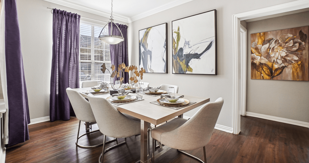 A dining room with a table set for a meal.