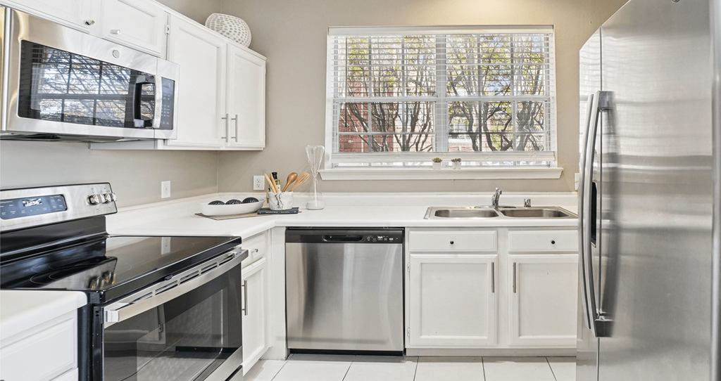 A kitchen with white cabinets and stainless steel appliances.