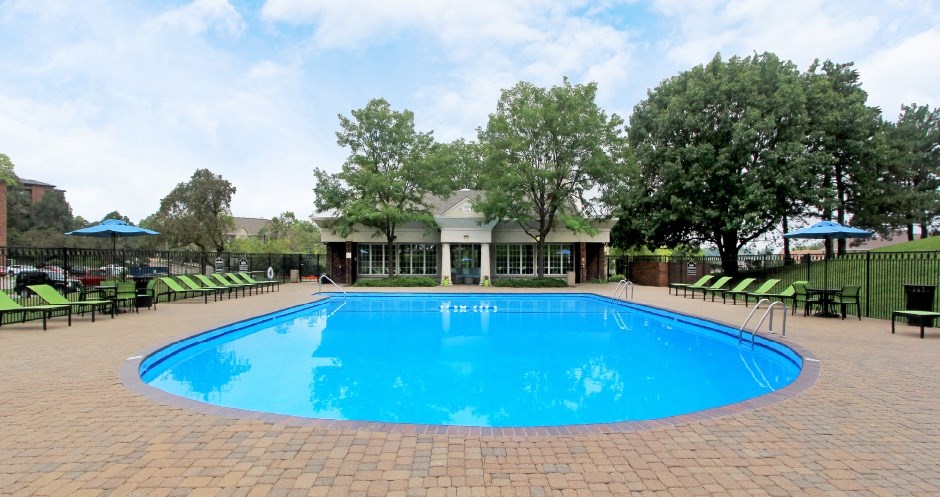 Resort-style saltwater pool with huge sun deck, poolside lounge chairs, and park-like setting with lots of trees and scenic views at Embassy Park Apartments in Omaha, Nebraska