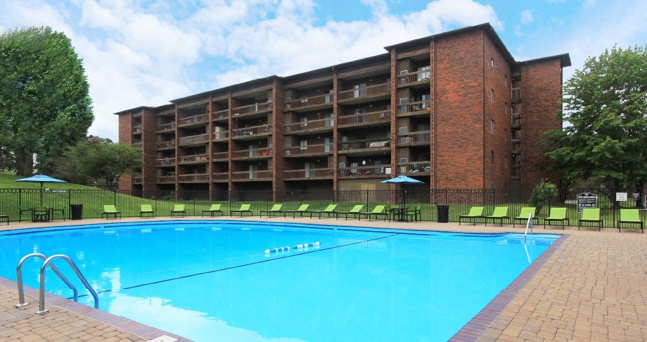 Resort-style saltwater pool with huge sun deck, poolside lounge chairs, huge balconies, and park-like setting with lots of trees and scenic views at Embassy Park Apartments in Omaha, Nebraska