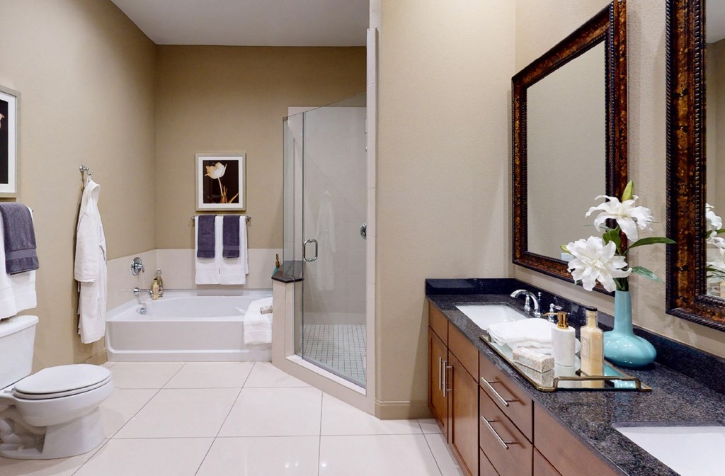 Spacious bathroom with oval soaking tub, separate shower with glass enclosure, cultured marble vanity at Tuscany Walk Apartments in Houston