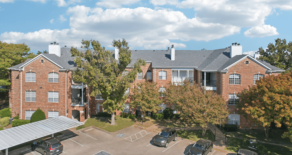 A large brick building with a parking lot in front.