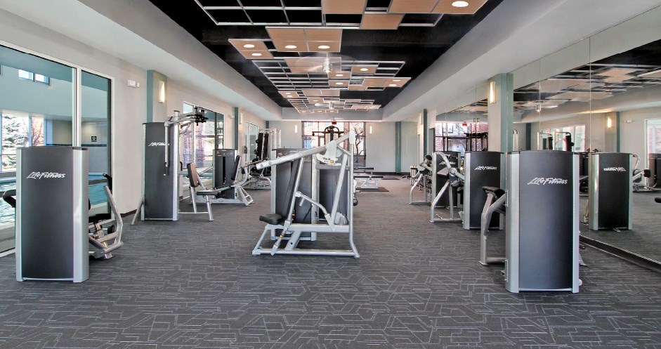 A gym with a variety of equipment including weights and machines.