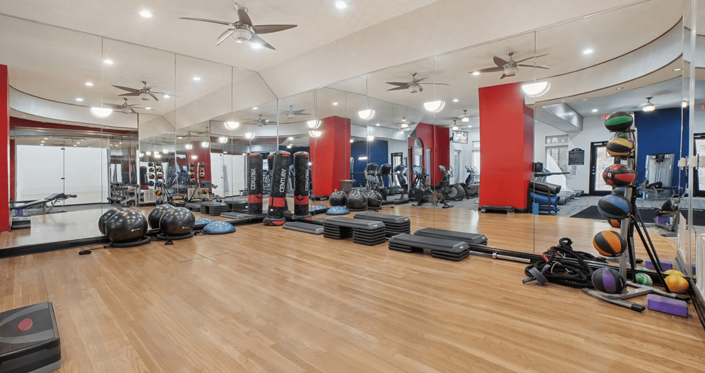 A gym with a variety of equipment including weights and exercise balls.
