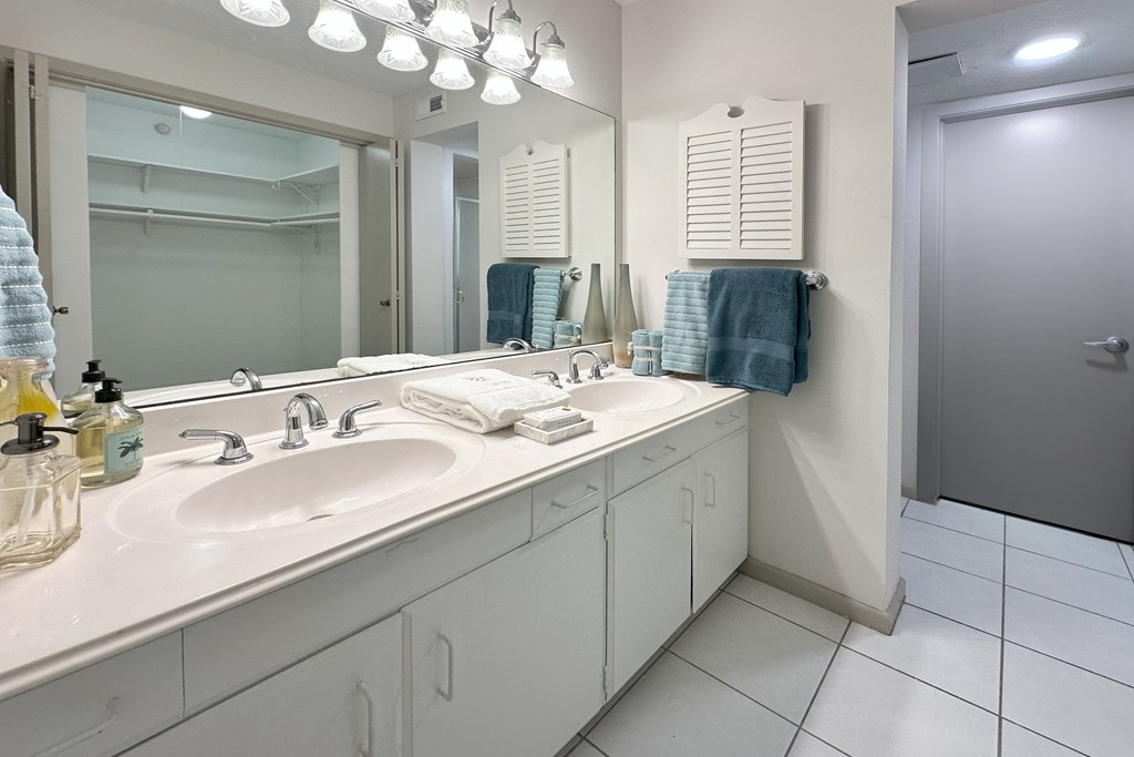 A bathroom with a white sink and a mirror above it.