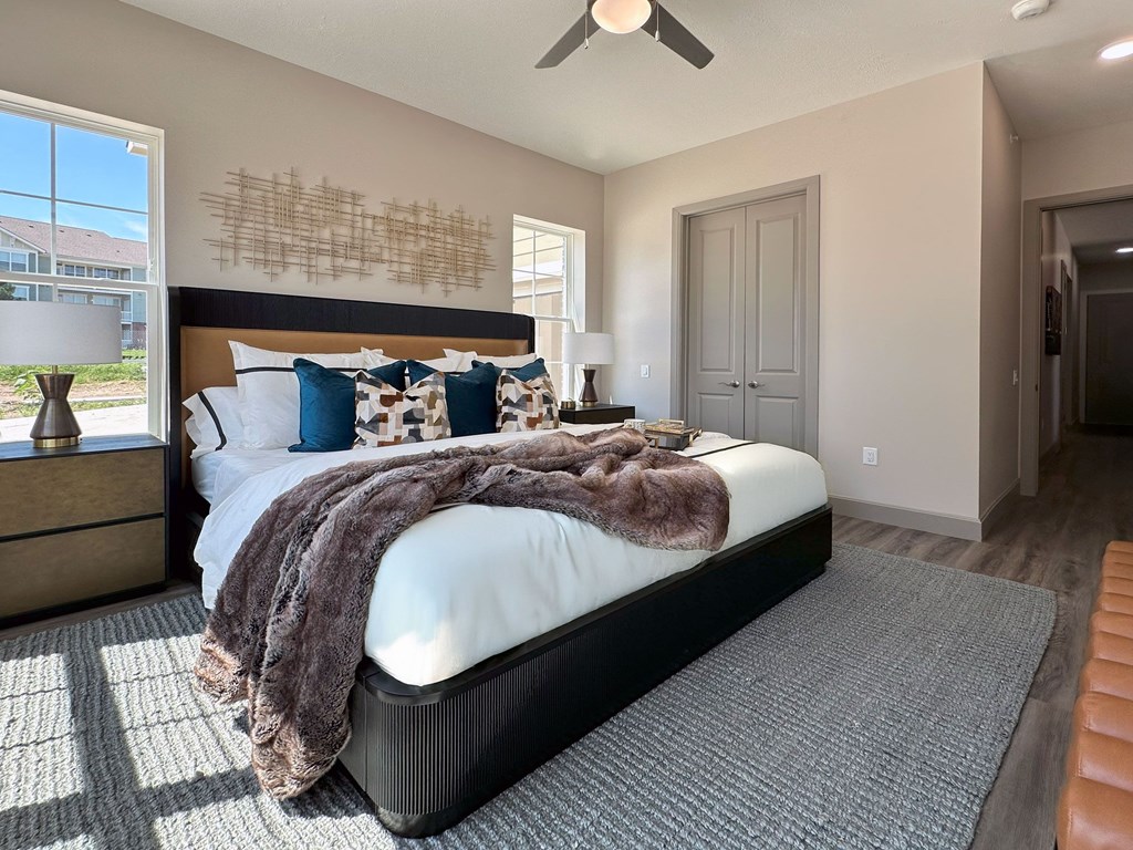 A bedroom with a large bed and a ceiling fan.