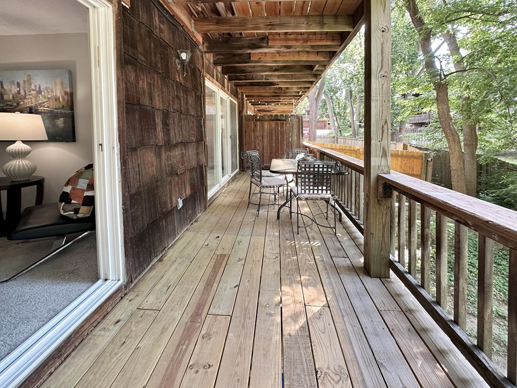 A wooden deck with a table and chairs.