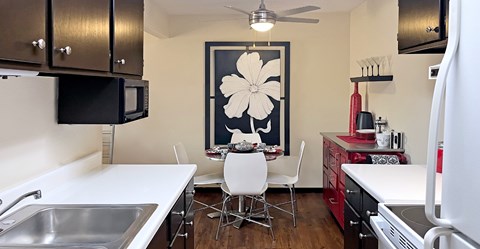 A kitchen with a white counter top and a white chair.