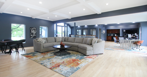 a large living room with blue walls and a gray couch