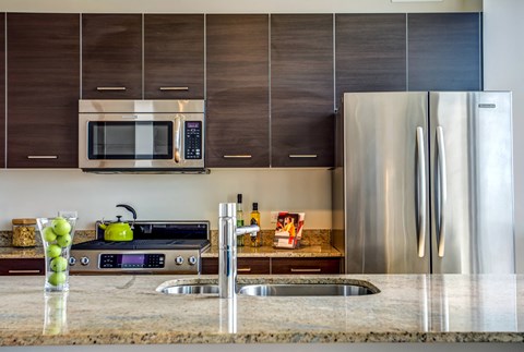 a modern kitchen with stainless steel appliances and granite counter tops