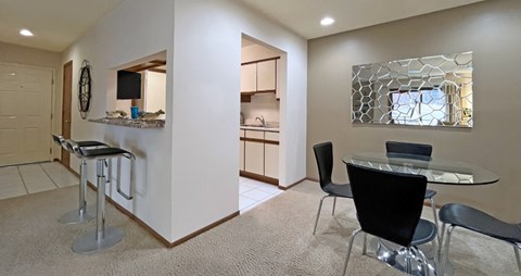 Dining room area with painted feature wall, granite breakfast bar, and kitchen with tiled floor at LionsHead Apartments in Omaha Nebraska