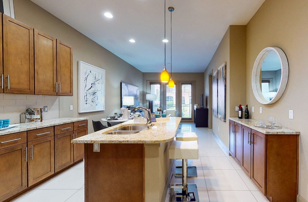 Luxury apartments in Bloomington Minnesota with spacious kitchen, granite countertops, stainless steel appliances, built-in wine rack, kitchen island, and porcelain tile floor at Luxembourg Apartments