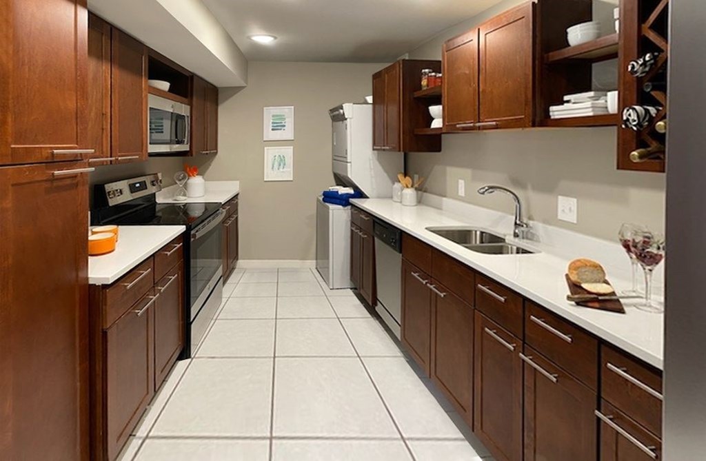 A kitchen with brown cabinets and white countertops.