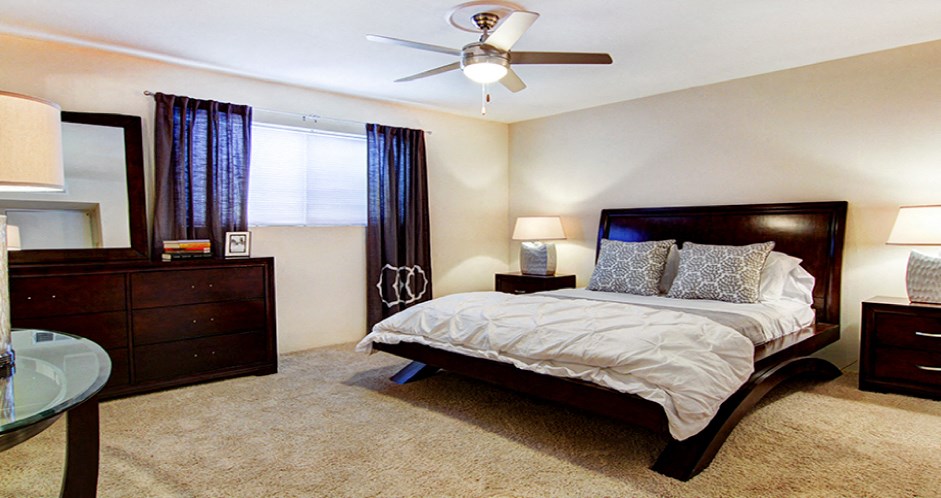 Spacious bedroom with ceiling fan and walk-in closet at Plantation apartments near the Galleria in Houston.