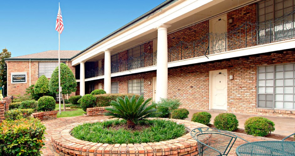 Apartments near the Galleria with brick exteriors, beautiful landscaping and courtyard setting at Plantation apartments in Houston.
