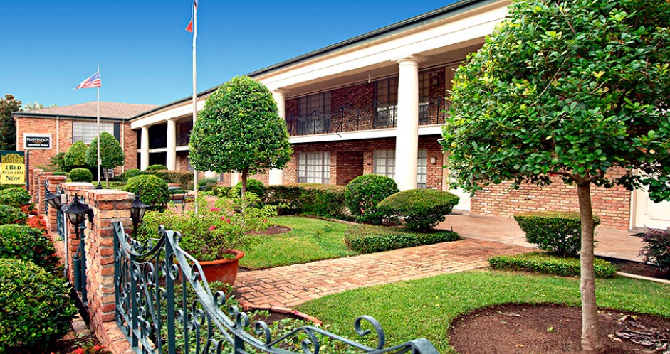 Apartments near the Galleria with brick exteriors, beautiful landscaping and courtyard setting at Plantation apartments in Houston.