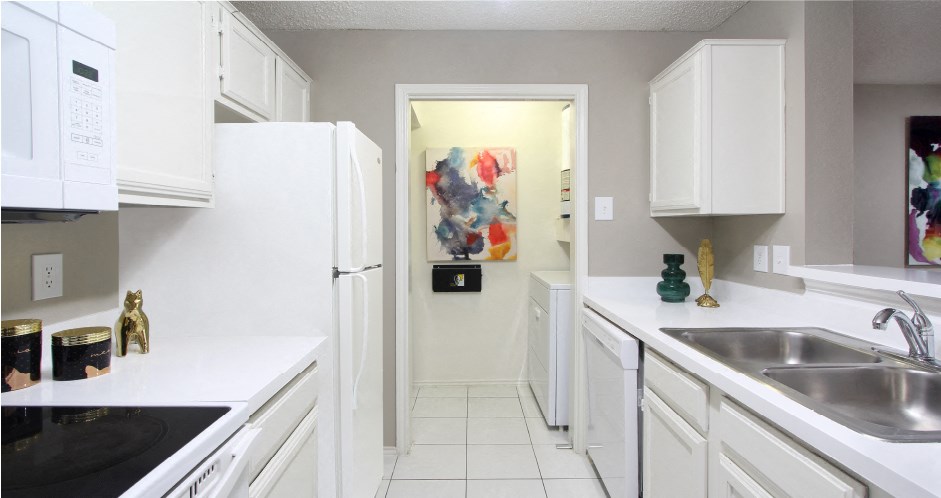 Bright white kitchen, spacious kitchen and full size and washer and dryer at Preston Village Apartments in North Dallas